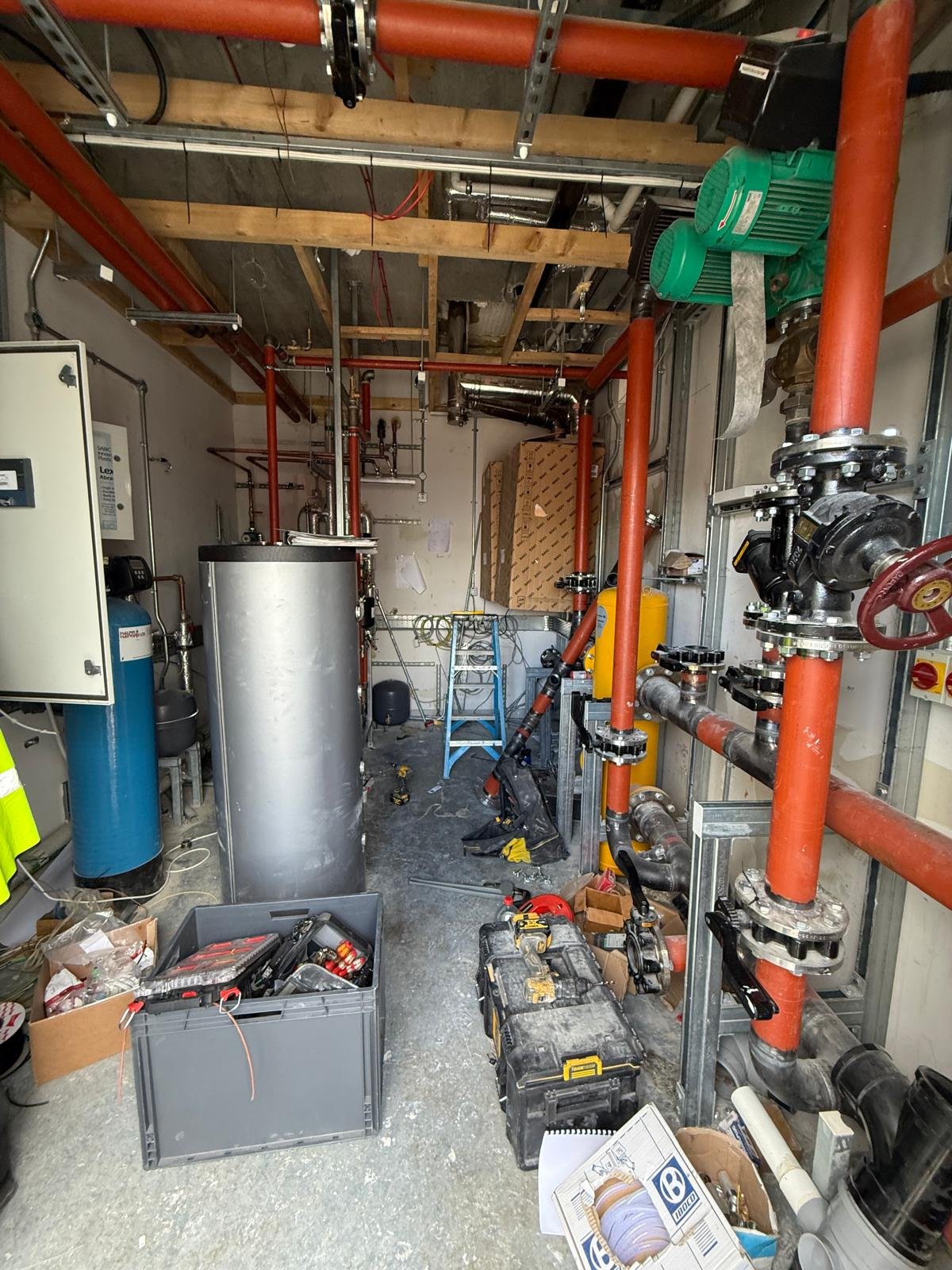 Red heating mains, pumps and cylinders in a plant room