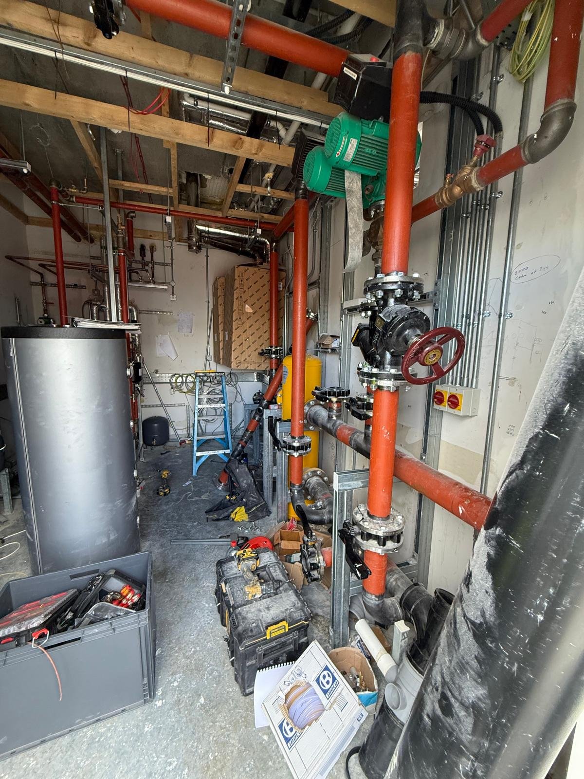 Red heating mains and valves in a commercial plant room